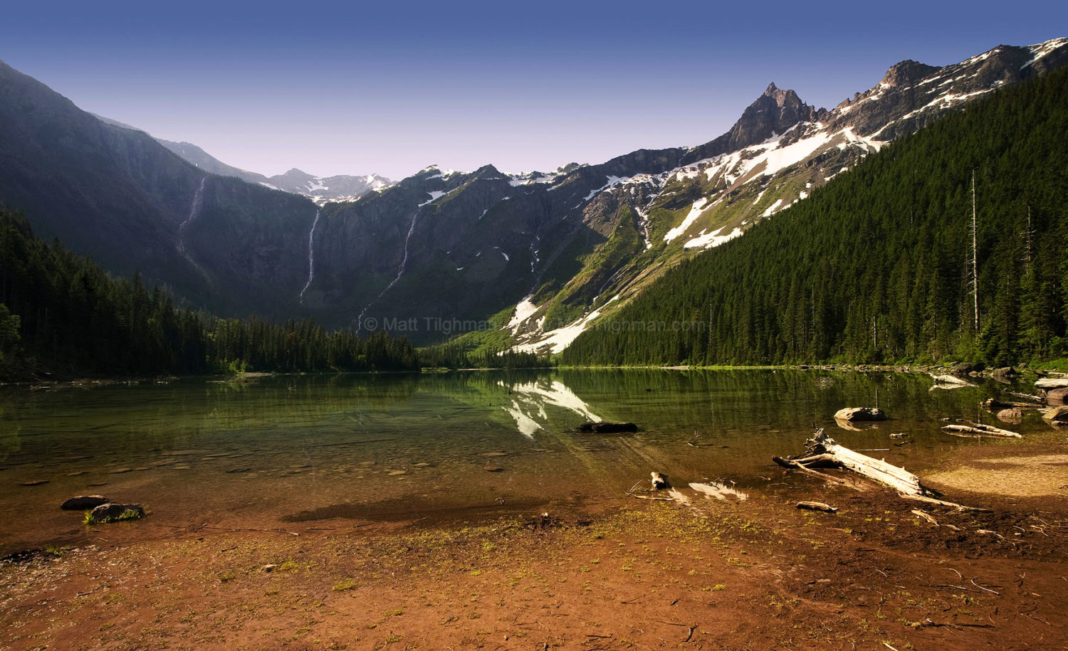 Fine art stock photograph of Avalanche Lake at dawn, flanked by towering mountains and boundless cascades fueled by snow melt. Glacier National Park, Montana.