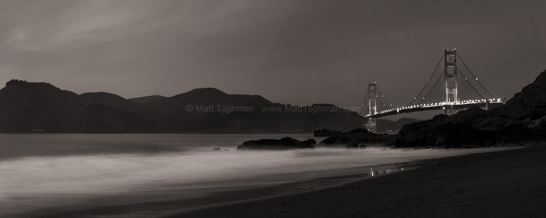 The Night's Watch over Golden Gate Fine art stock panorama of the Golden Gate Bridge and dramatic Marin Headlands at night, as the bridge seems to guard the bay against the mighty Pacific Ocean.