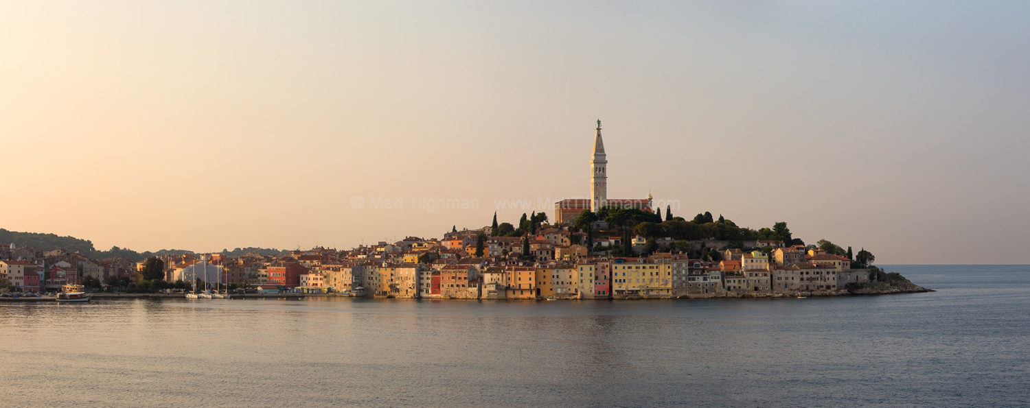 Fine art stock photograph of the beautiful waterfront of Rovinj Croatia at dawn, in Istria, with the Church of Saint Euphemia atop the hill.