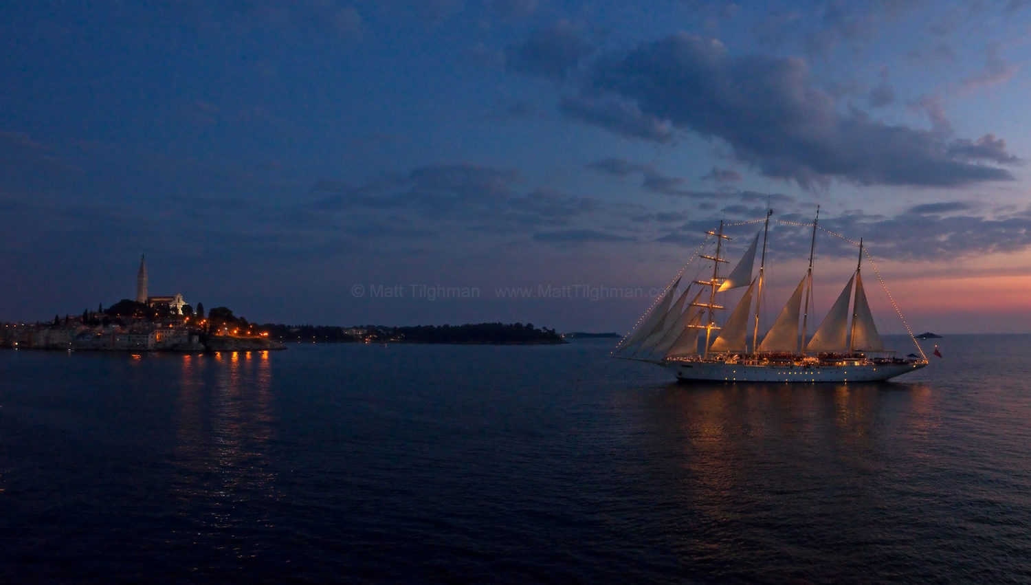 Fine art stock photograph of a beautiful sailboat sailing into the peaceful harbor of Rovinj, a small town in the Istria portion of Croatia.