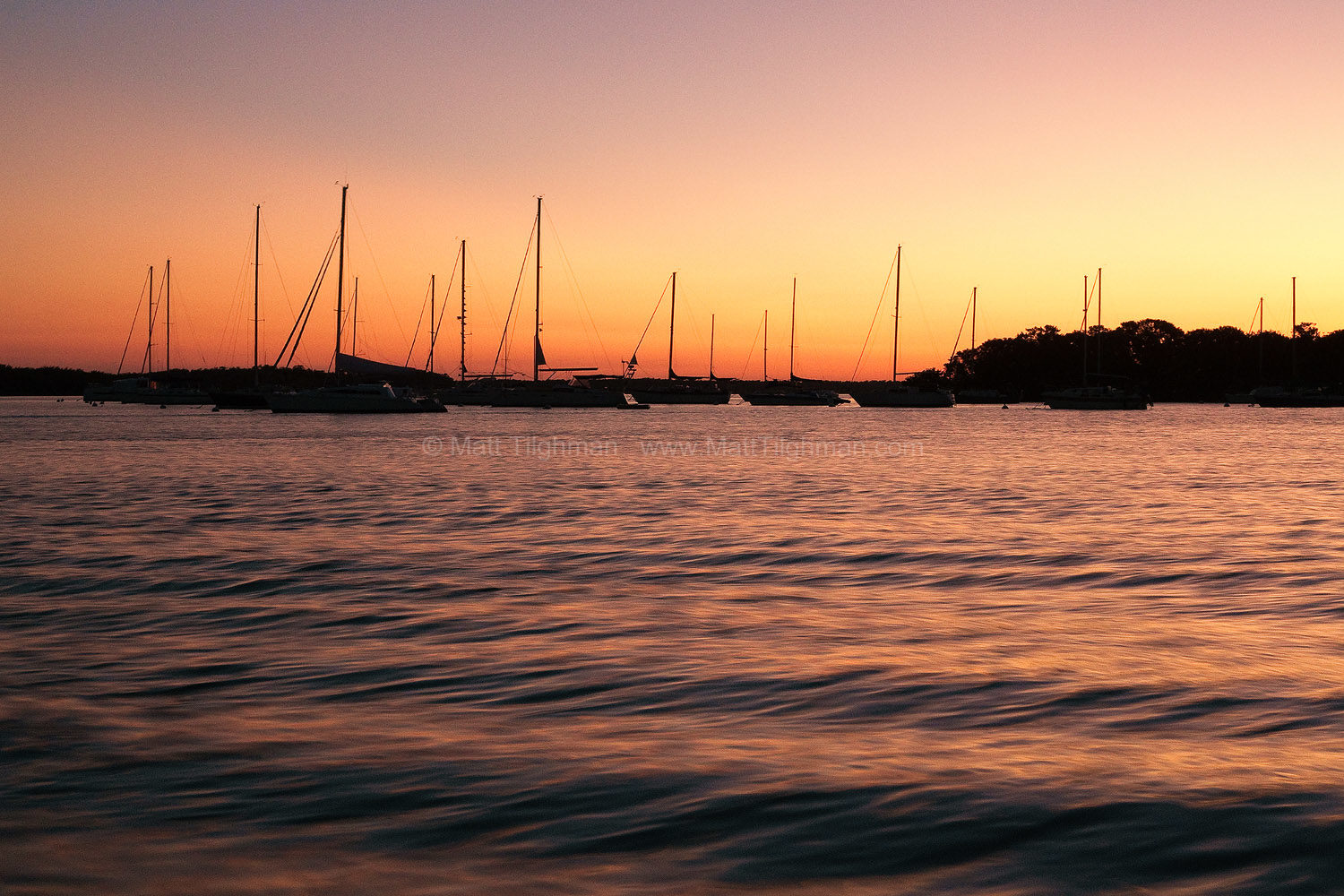 Fine art stock photograph from Key Biscayne, Florida. The silhouetted sailboats frame a beautiful sunset over Biscayne Bay, near Miami.