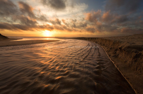 Fine art stock photograph from Montara State Beach, near Pacifica, California. Martini Creek finds its way to the Pacific Ocean as the sun sets beyond.