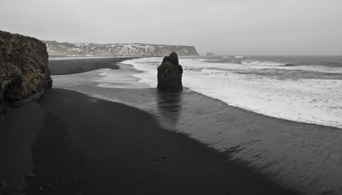 Fine art stock photograph from Iceland's Reynisfjara Beach, seen from Dyrhólaey. With its famous black sand, it takes on an ominous tone in stormy weather.